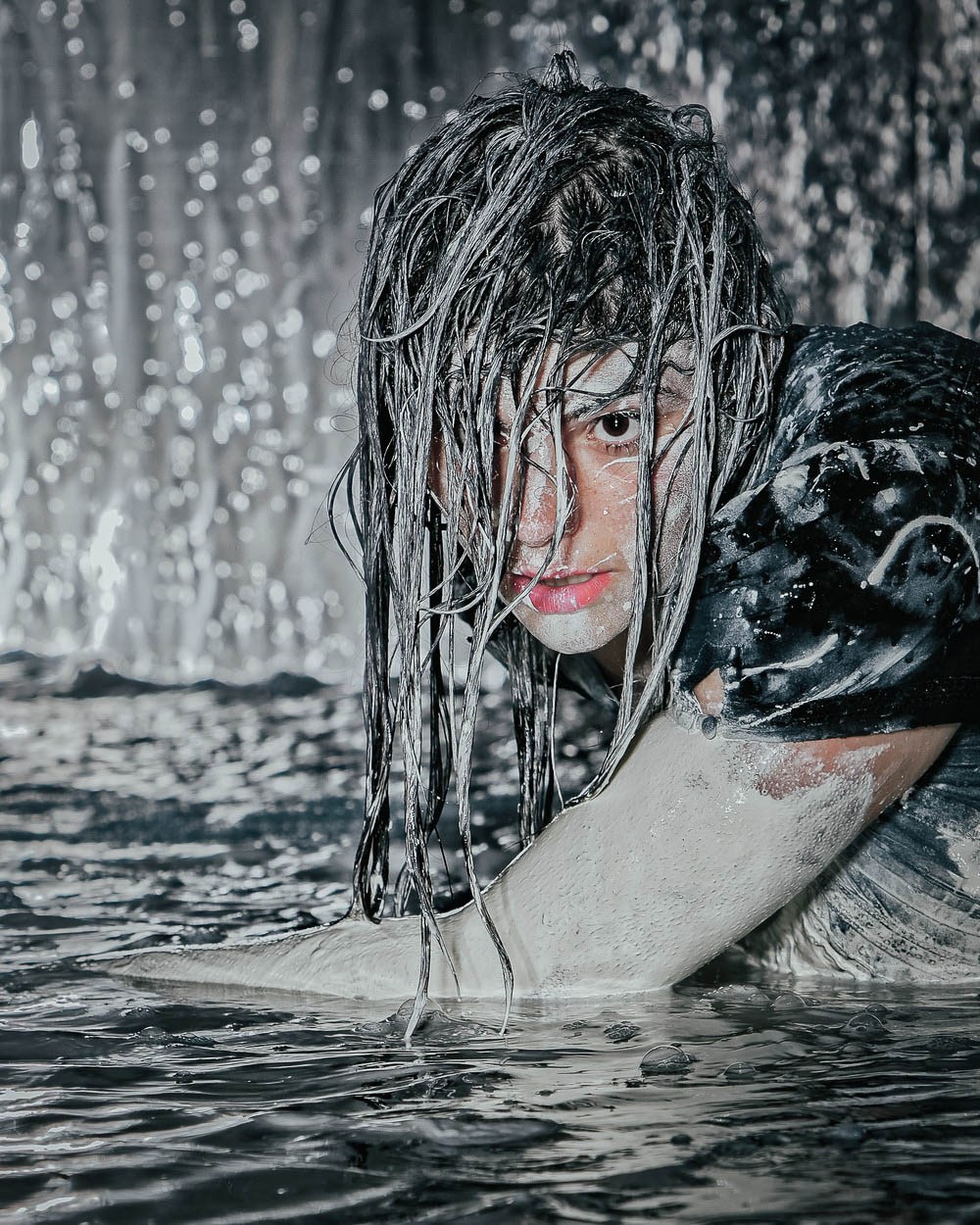 A close portrait reflected and distorted through rippling water.