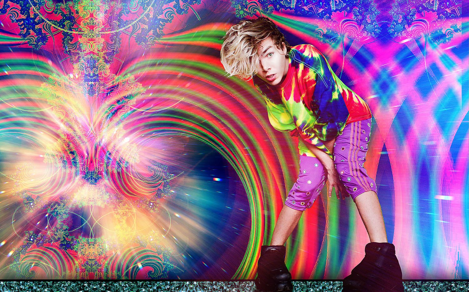 A model in colourful sportswear leaning into a psychedelic rainbow backdrop.