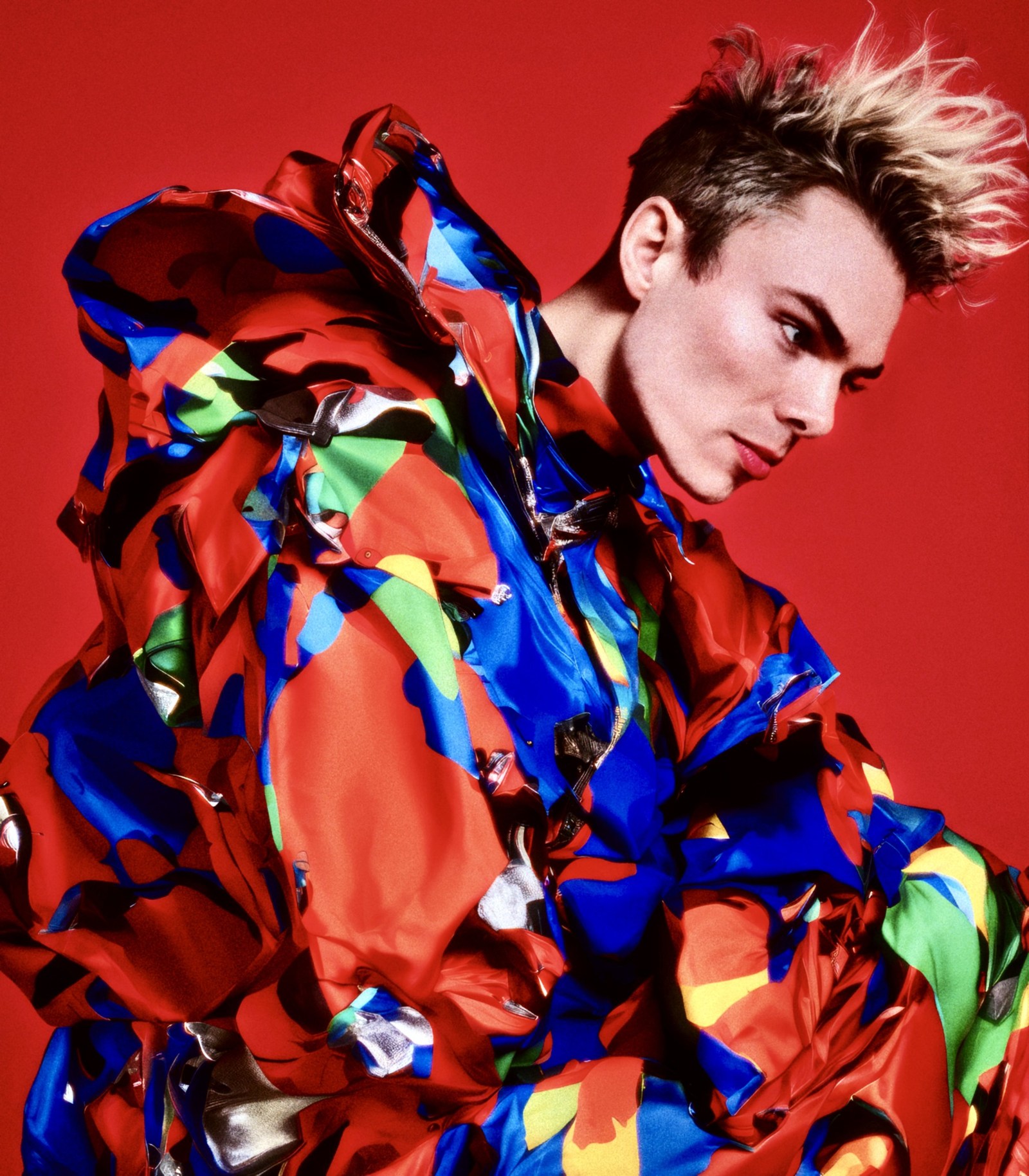 WORM crouching in a multicoloured patterned outfit against red.