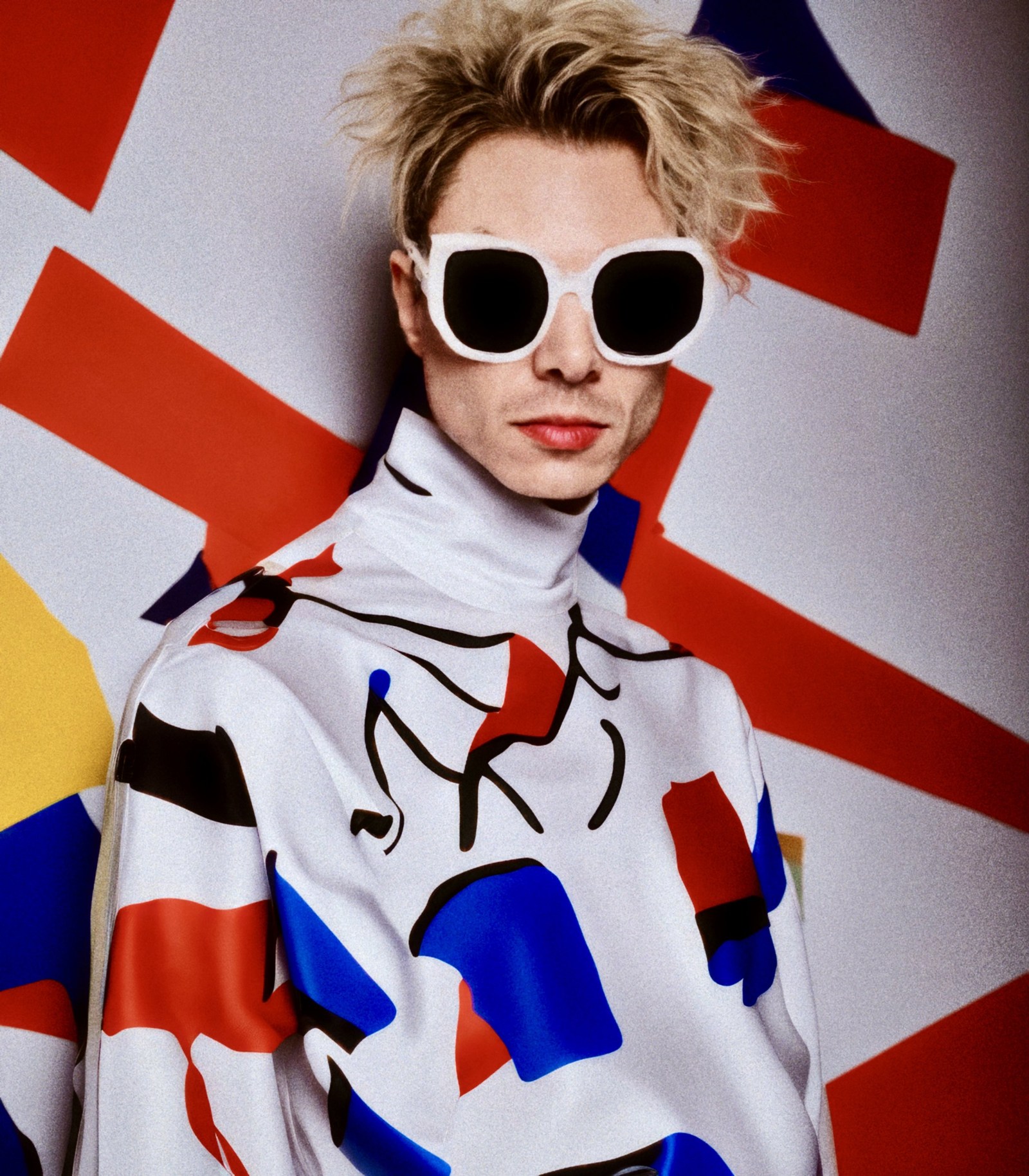WORM in white sunglasses and a graphic printed top against red and white shapes.
