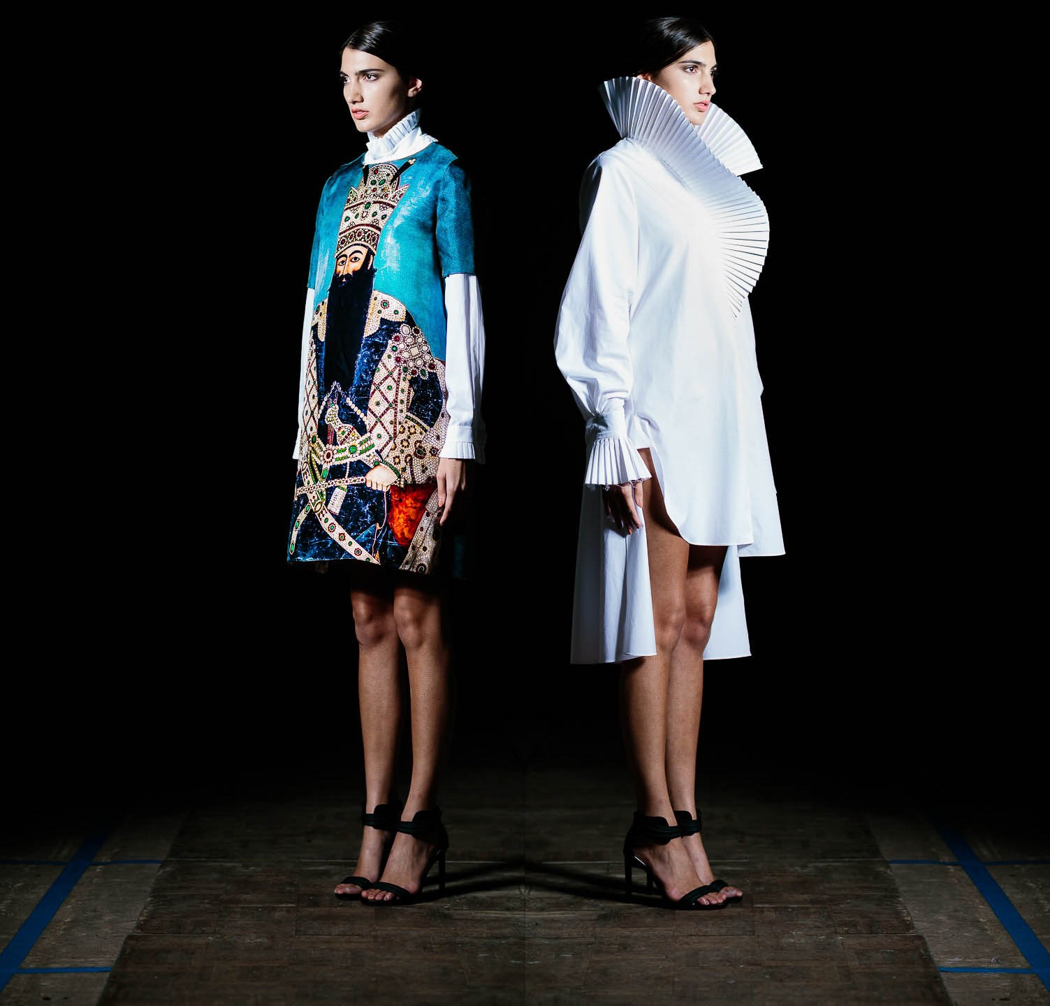 Two models on a dark runway, one in a colourful print and the other in white.