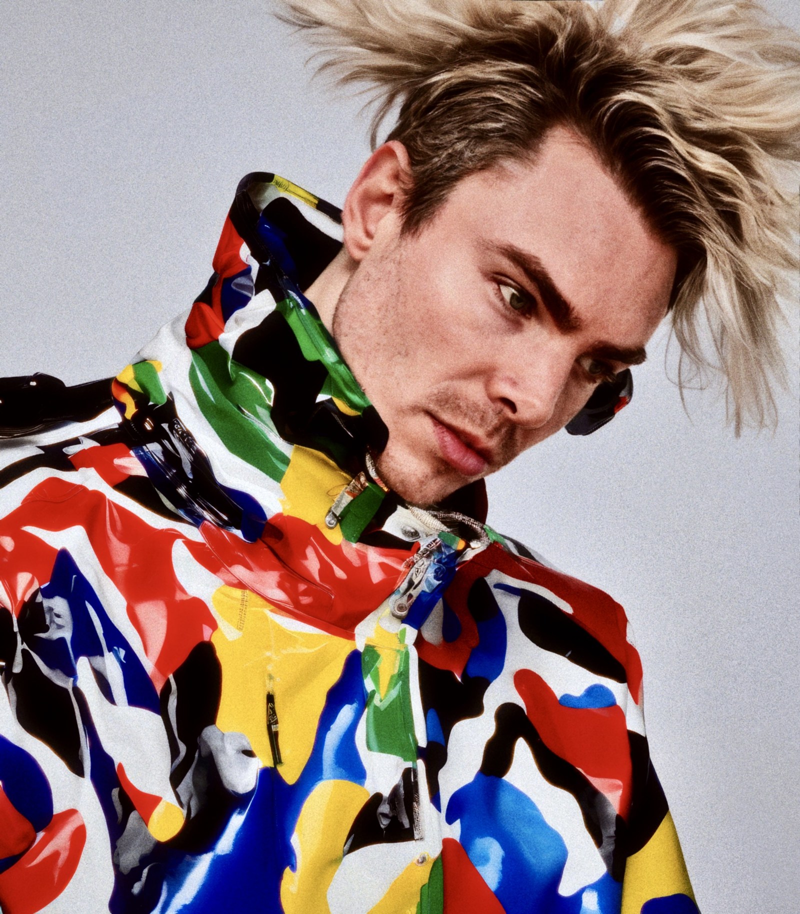 Close WORM portrait above the high collar of a brightly patterned jacket.