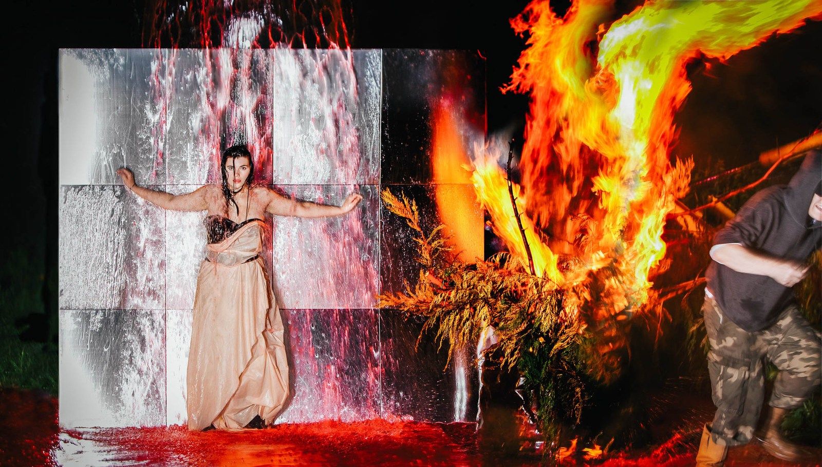 A fashion figure in a pale dress within a collage of architectural textures and bright flames.
