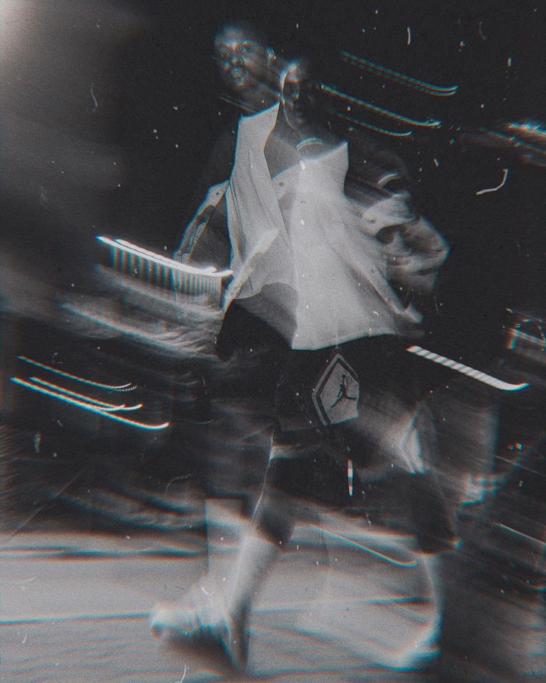 A performer in a white shirt surrounded by blurred streaks of light.