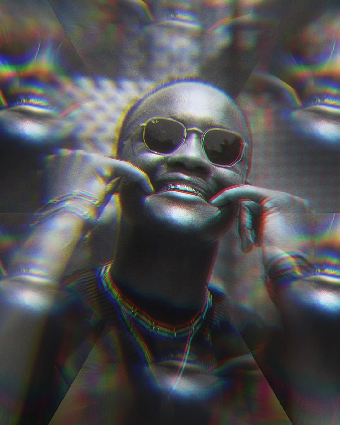 A model in dark sunglasses seen through rainbow-edged optical distortions.